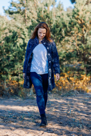 Female portrait. Beautiful young girl with long dark hair on a sunny autumn day outdoors. Vertical photo. High quality photoの写真素材