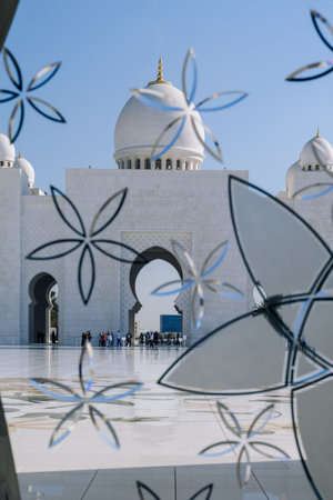 Sheikh Zayed Grand Mosque in Abu Dhabi made of white marble with flowers made of precious. Colored stained glass windows with blue flowersの写真素材