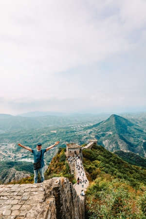 Man on Simatai section of Great Wall of China in its original, un-restored state. Watchtowers perched on mountain peaks, China, Beijing. Vertical photoの写真素材