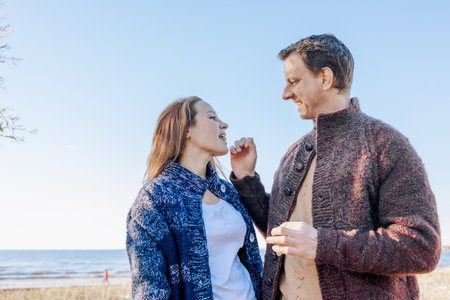 Happy beautiful couple in love enjoying autumn picnic on coast in open air. Weekend and lifestyle concept. High quality photoの写真素材