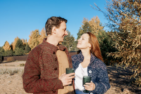 Happy beautiful couple in love enjoying autumn picnic in park. Weekend and lifestyle concept. High quality photoの写真素材