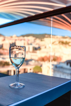 Glass of white wine on table in sunlight. Atmosphere of delightful event. Vertical photoの写真素材