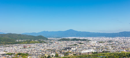 Urban Landscape. View of Kyoto from elevated viewpoint, dense buildings, natural forest foreground,...