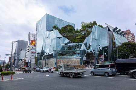 Tokyo, Japan - October 9, 2025: People passing Dior flagship fashion store with large glass facade...