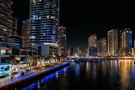 Dubai, UAE - December 9, 2024: view of Dubai Marina promenade at night. Night illumination with...