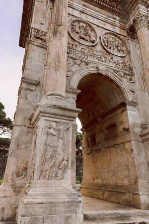 Rome, Italy - December 6, 2023: Close-up. Arch of Titus with tourists in Roman Forum historic...