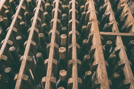 Old wine bottles in the wine cellar, blurred defocused backgroundの写真素材