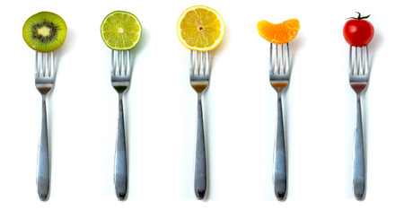Mix of fruits and vegetables on forks in white background の写真素材