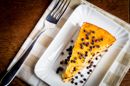 Slice of delicious homemade cake with pears and choco chips on wooden tableの写真素材