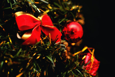 The branch of a Christmas tree with Christmas decorations on a black backgroundの写真素材