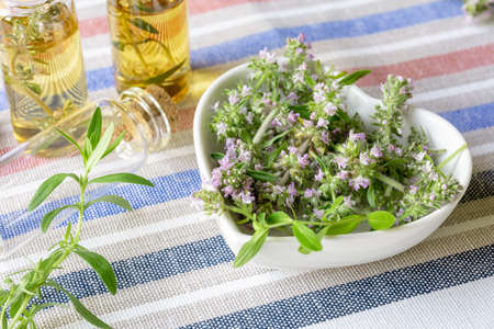 Sliced flowering thyme in a white heart-shaped plate and bubbles with essential thyme oil....