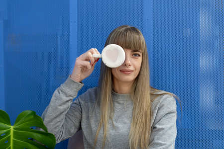 A ceramic tea mug with a pink heart painted on the bottom in the hand of a smiling woman. A pretty...