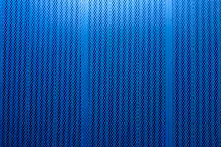 Perforated metal blue panel or wall. Lightweight design for space separation. Urban background. Perforated metal sheet with rivets. Copy spaceの写真素材
