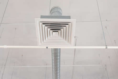 Pipe of the supply and exhaust ventilation system on the ceiling of a commercial room or warehouse.