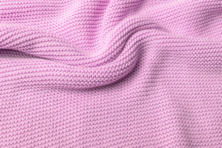 Pink knitted fabric background. Purl loops close-up. Crumpled curved surface. Copy space