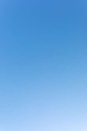 clear blue sky. gradient from dark to light. vertical frameの写真素材