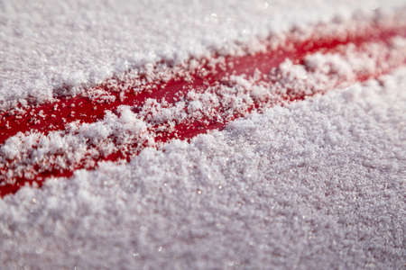 Fluffy snow flakes on the red metal background. the concept of the first snowの写真素材