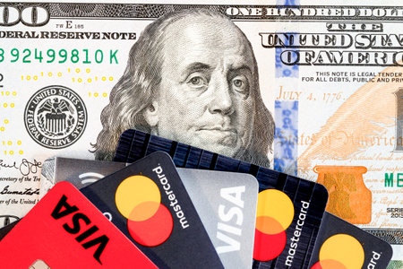 VISA and MasterCard bank cards on a 100 US dollars banknote. VISA American multinational financial services corporation. Master Card International payment system. Voronezh, Russia - March 5, 2021のeditorial素材