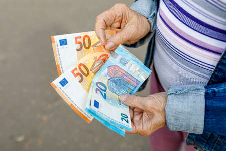 Hands of a senior citizen with euro notes, senior citizen counts her money,の写真素材