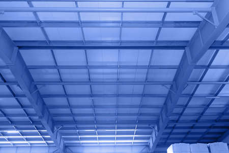 complex vaulted ceiling with crossbars beams ceilings inside factory building for industrial background. Metal structures on the ceiling of industrial building, warehouse, workshop. Tintedの写真素材