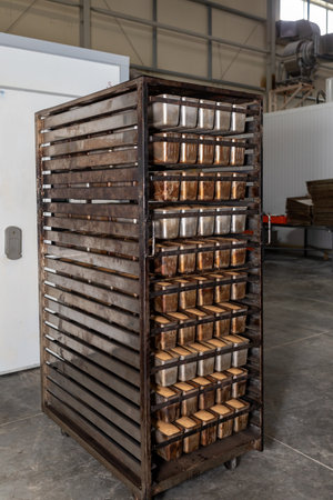 Metal racks with freshly baked loaves of fresh wheat bread. Fresh bread on a mobile rack with...