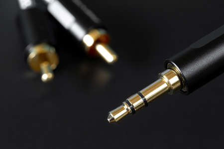 The gold-plated TRS connector and RCA connectors for sound transmission, audio cable for excellent sound quality. White and red bell on black backgroundの写真素材