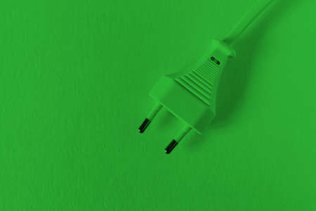 European power plug (Type C, 2 Pins) on a green background. The concept of clean eco-friendly renewable energy. Copy spaceの写真素材