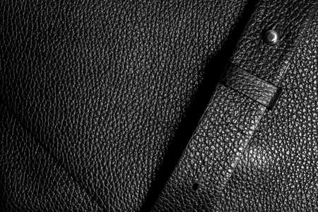 Genuine leather of black color. Natural textured leather background with shoulder strapの写真素材