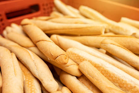 Baked fresh baguettes in plastic boxes in a bakery warehouse. Finished products before transportation to the store. selective focusの写真素材