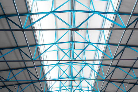 Warehouse ceiling background with one window opening. Roof steel beam structure in Industrial factoryの写真素材