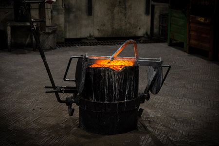 A Hot steel vat with molten metal stands on a metal floor. Safety at the metallurgical plant. Heavy industry conceptの写真素材
