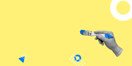 The hand with the brush is ready for drawing or writing with blue paint on a yellow background. A blank for a design in a minimalistic style. copy spaceの写真素材