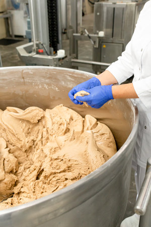 Quality control check of dough in bakery production by a technologist. The technologist checks the...