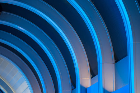 Ceiling lighting. Ceiling with curved blue and white LED light strips for modern architecture,...