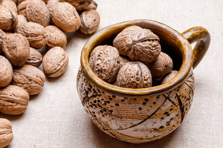 large ceramic cup with ripe walnuts close-up.の写真素材