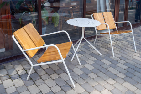 Small modern patio set with two chairs and perforated table. Typical for outdoor dining and resting...