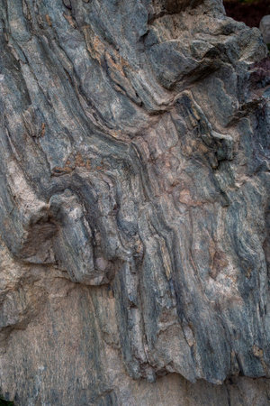 Eroded stone formation with natural wavy patterns. Shows geological structure and rock aging. Stone...