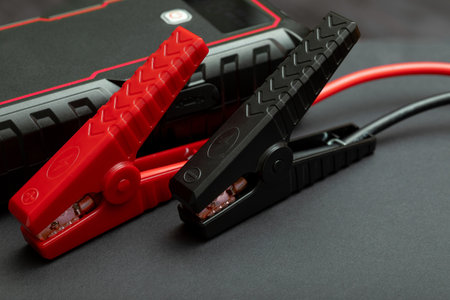Crossed jumper clips resting on starter unit. Heavy duty battery clamps connected to portable power...