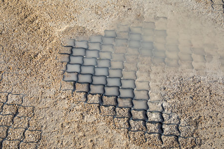 Polymer geogrid with gravel fill showing soil stabilization under wet conditions. For erosion control, permeable pavement, and road construction projects. Real photoの写真素材