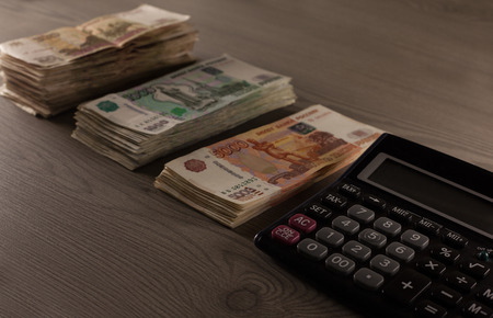 Money. Russian rubles and calculator on a wooden background. Bundles of moneyの写真素材