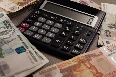 Money. A lot of russian rubles and calculator on a wooden background.の写真素材