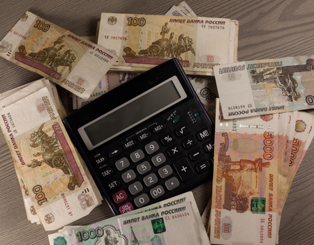 Money. A lot of russian rubles and calculator on a wooden background.の写真素材