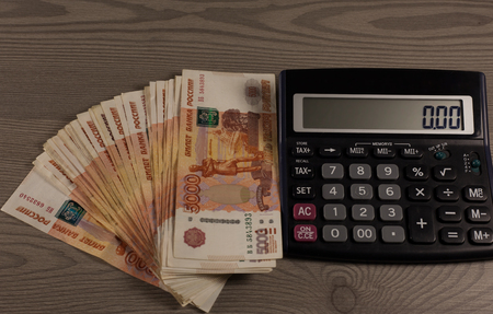 Money. A lot of russian rubles and calculator on a wooden background.の写真素材