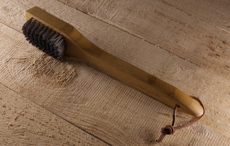 Side view of cleaning brush for barbecue. Rustic wood background.の写真素材