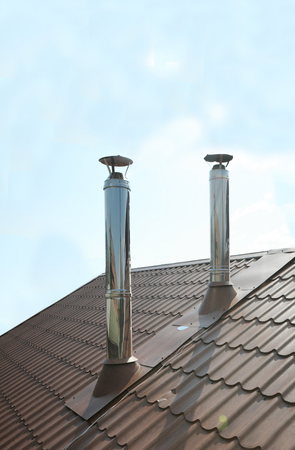 Two chimneys against the blue sky backgroundの写真素材