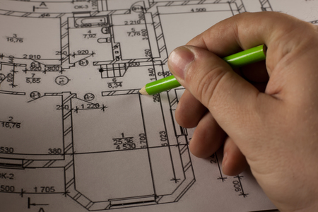 Hand with pencil on plan of the houseの写真素材