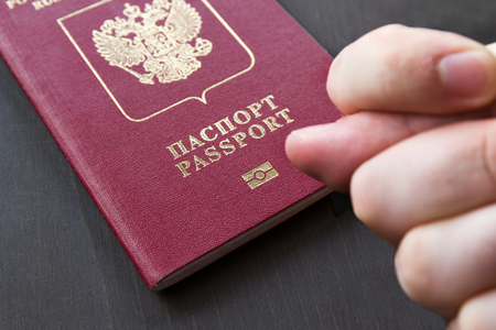 Hand showing the fig sign, on red russain passport background.の写真素材