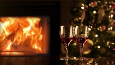 Two glasses of red wine by fireplace. Cozy romantic evening near the fireplace.の写真素材