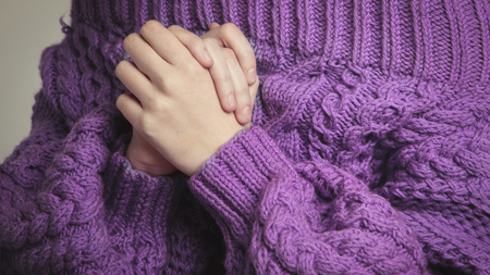 Closeup of beautiful woman in knitted, purple oversize sweater on white background.の写真素材