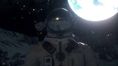 Astronaut stands on the surface of the moon among craters against the backdrop of the planet earth....